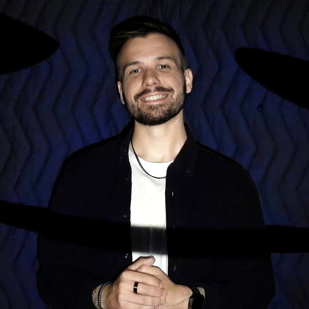 A square photo of Vlad (Vladimir) Dorokhin in front of a black background under blue lighting.
